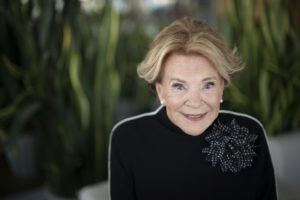 Janette Bertrand habillée en noir regarde l'écran avec un beau sourire.